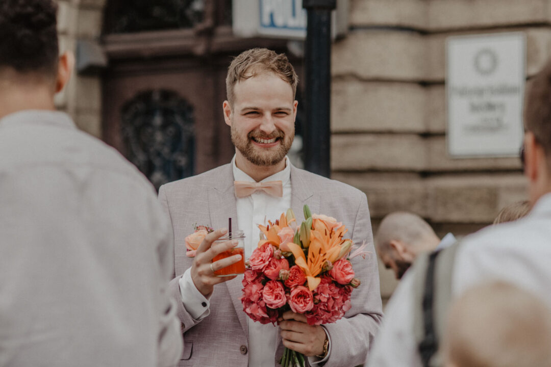 Bräutigam mit Cocktail und Brautstrauß
