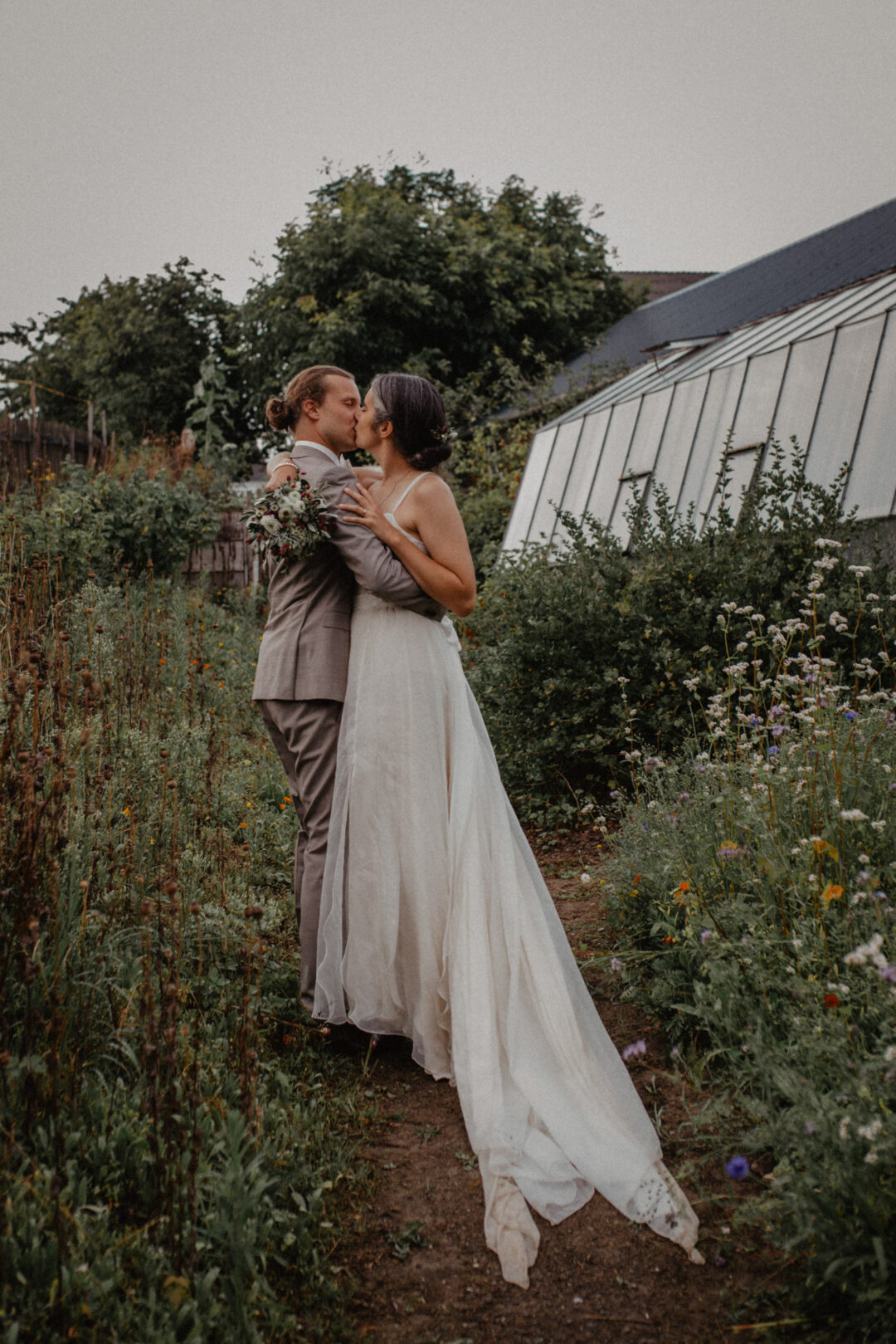 Paar küsst sich im blühenden Gemüsegarten