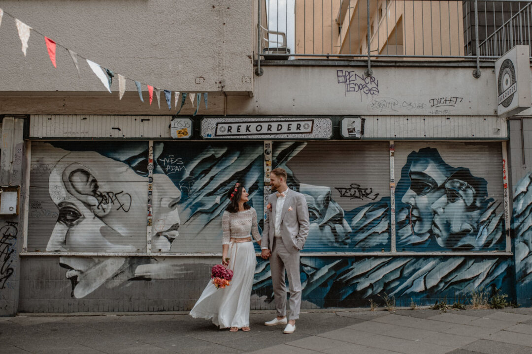 Brautpaar steht vor Streetart in Dortmund