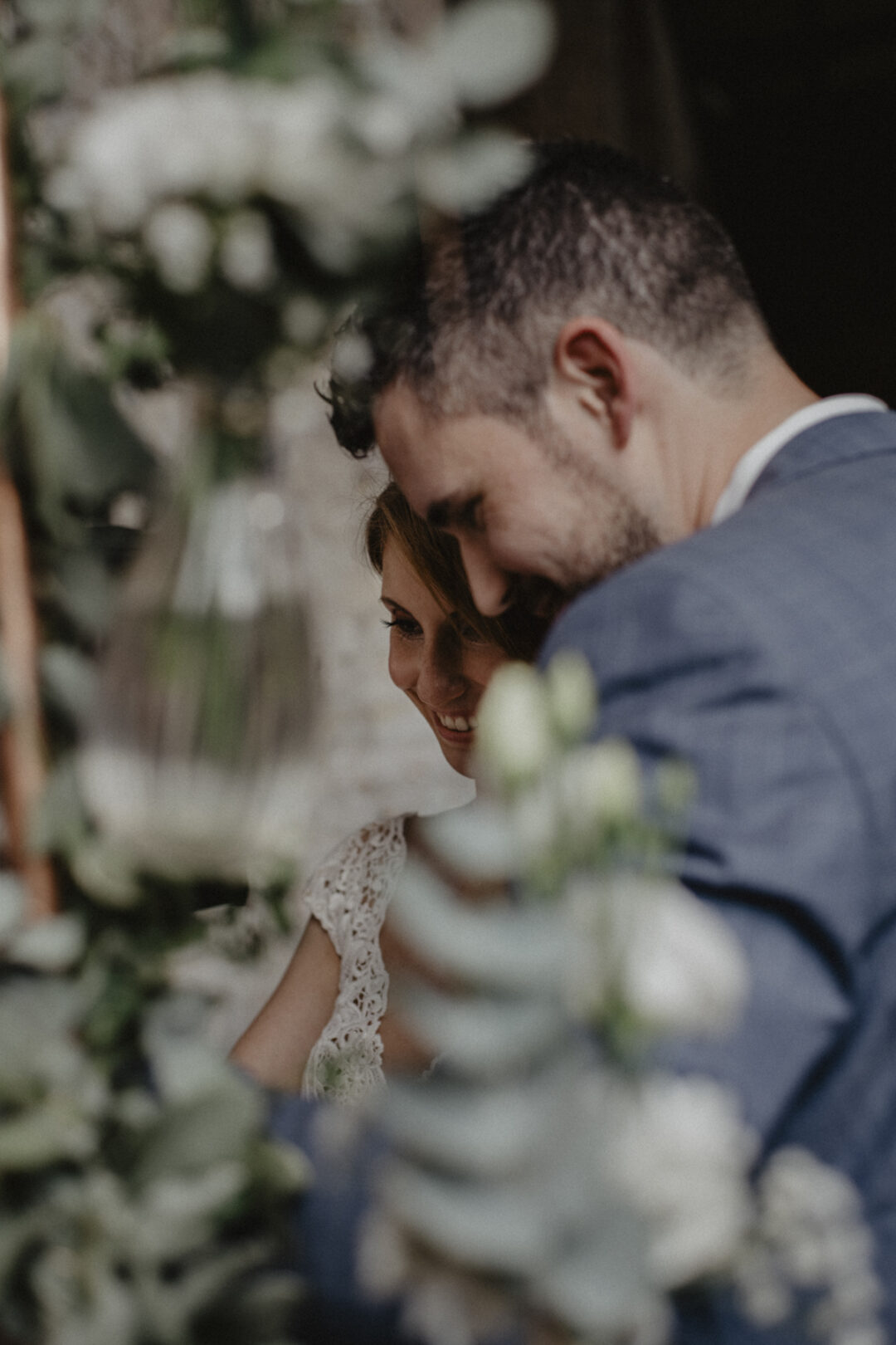 Brautpaar versteckt sich hinter dem Traubogen während der freien Trauung