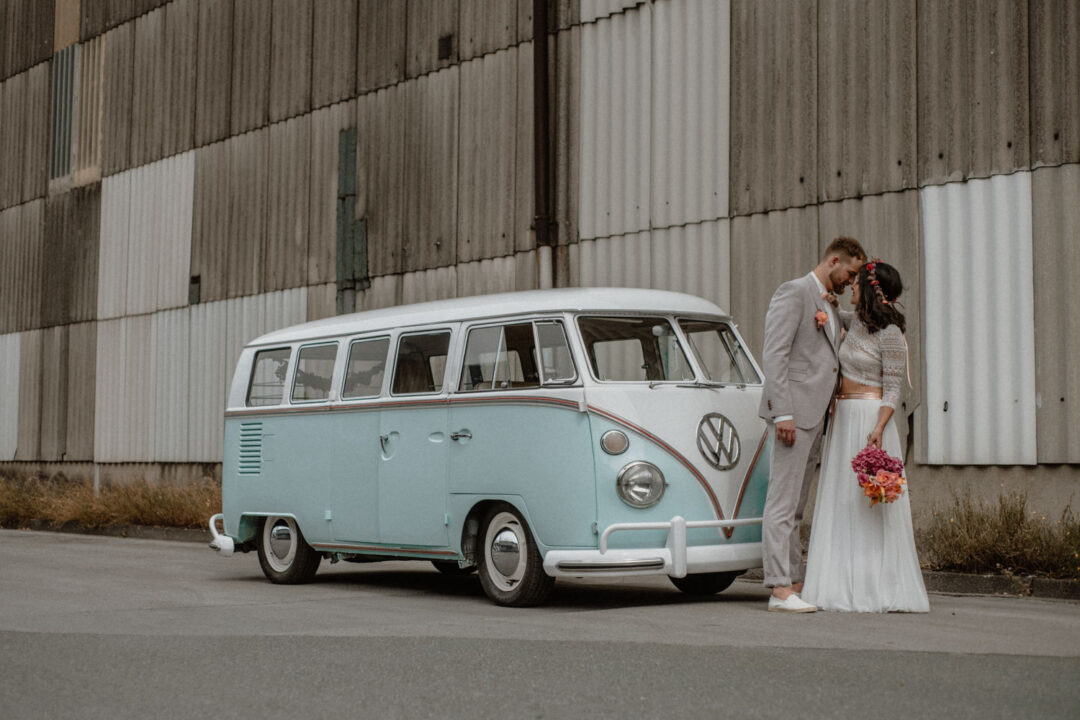 Paar steht vor mintgrünem Bulli