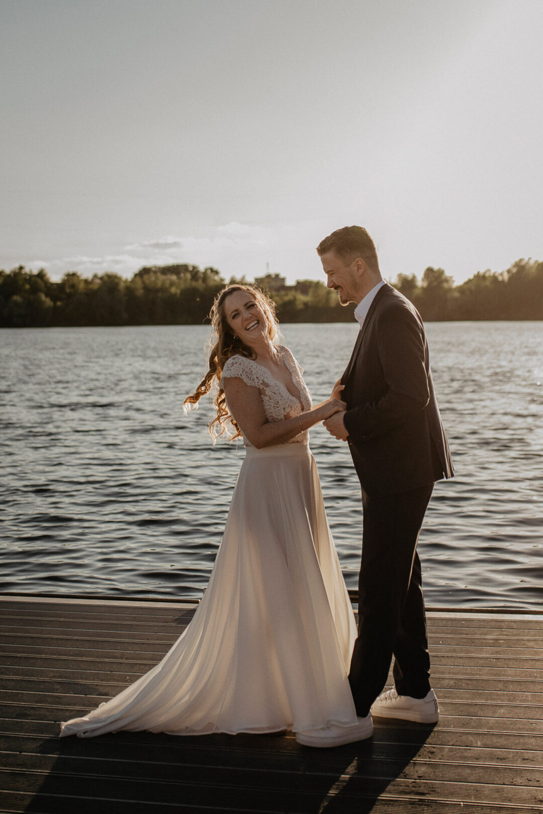 Brautpaar lacht am Steg des Wassersportzentrums