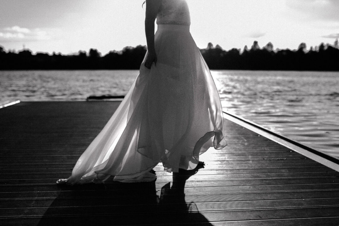 Fließendes Brautkleid im Gegenlicht am See