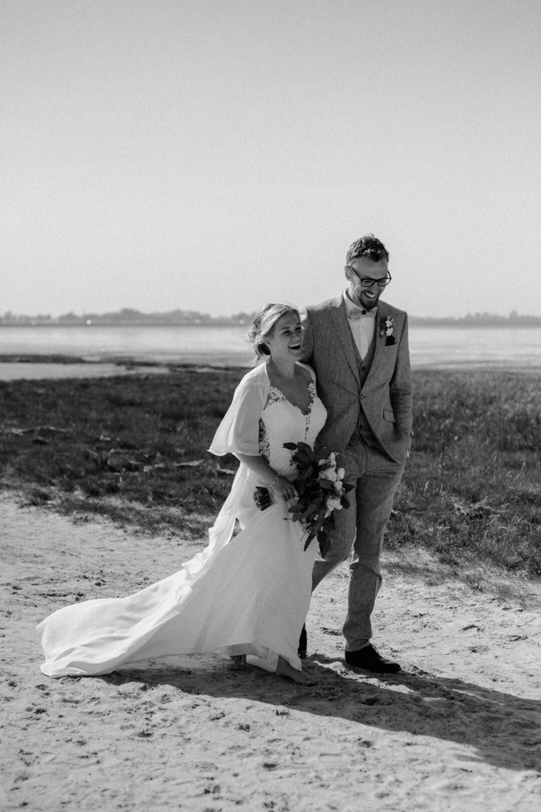 Brautpaar läuft gemeinsam durch die Dünen