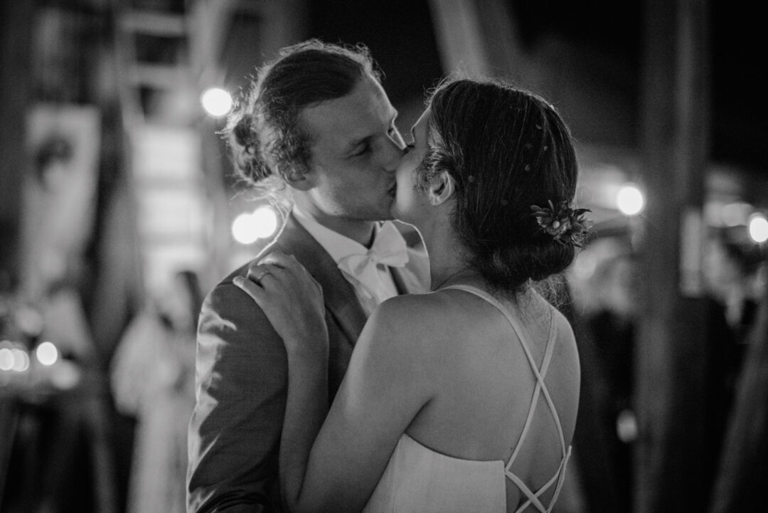 Brautpaar küsst sich bei erstem Tanz in der Scheune