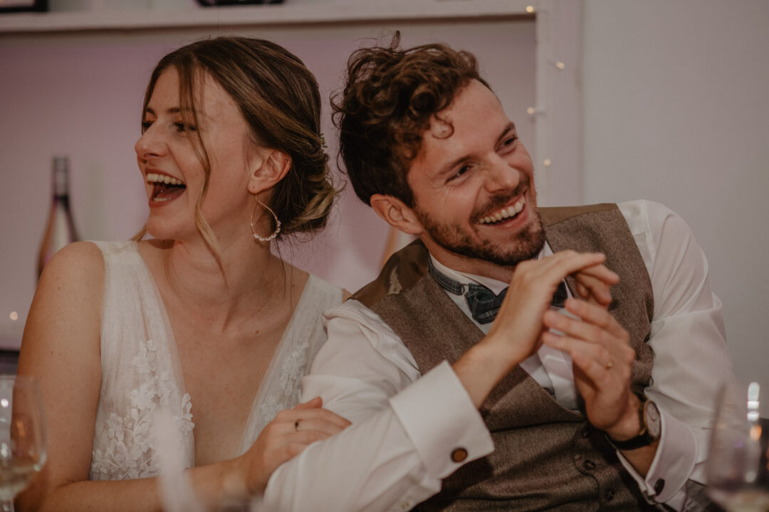 Brautpaar lacht herzlich beim gemeinsamen Dinner