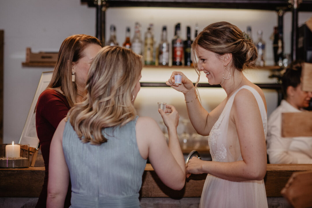 Braut stößt mit Freundinnen bei der Hochzeitsfeier an