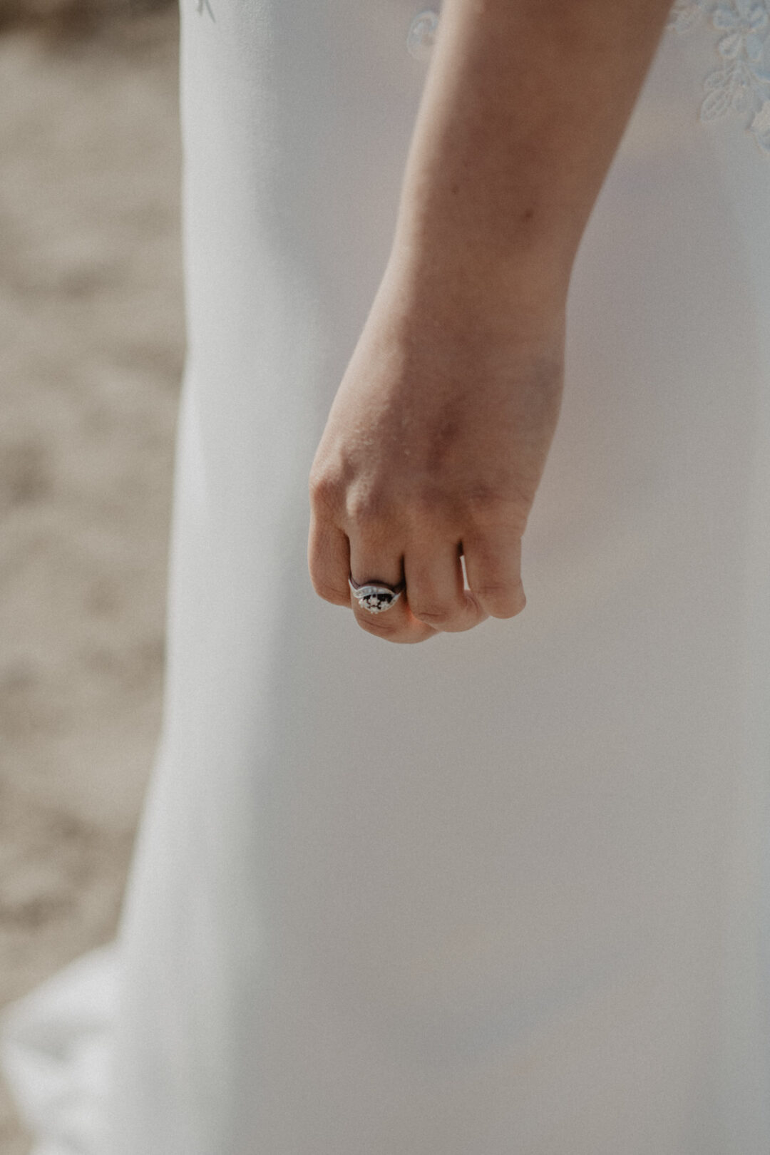 Hand der Braut am Kleid