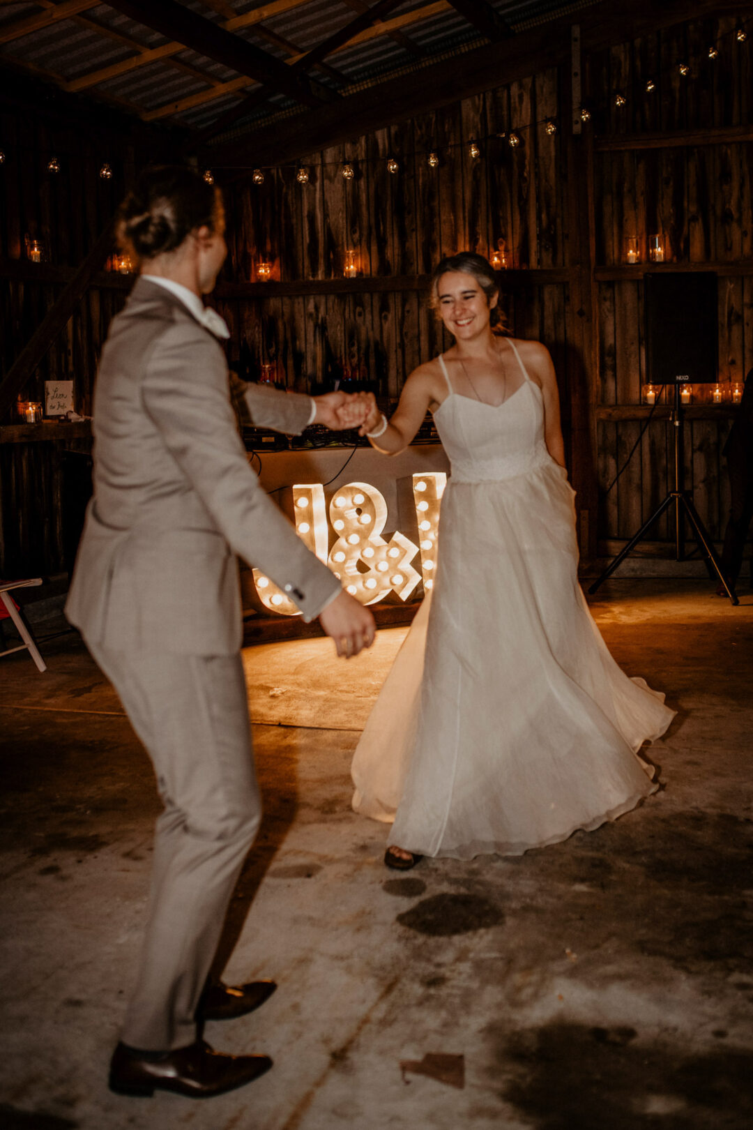 Brautpaar tanzt beschwingt in rustikaler Location