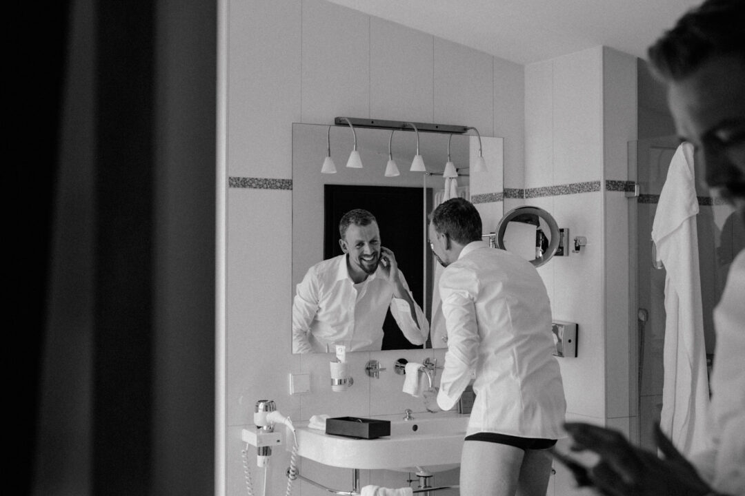 Bräutigam rasiert sich vor dem Spiegel