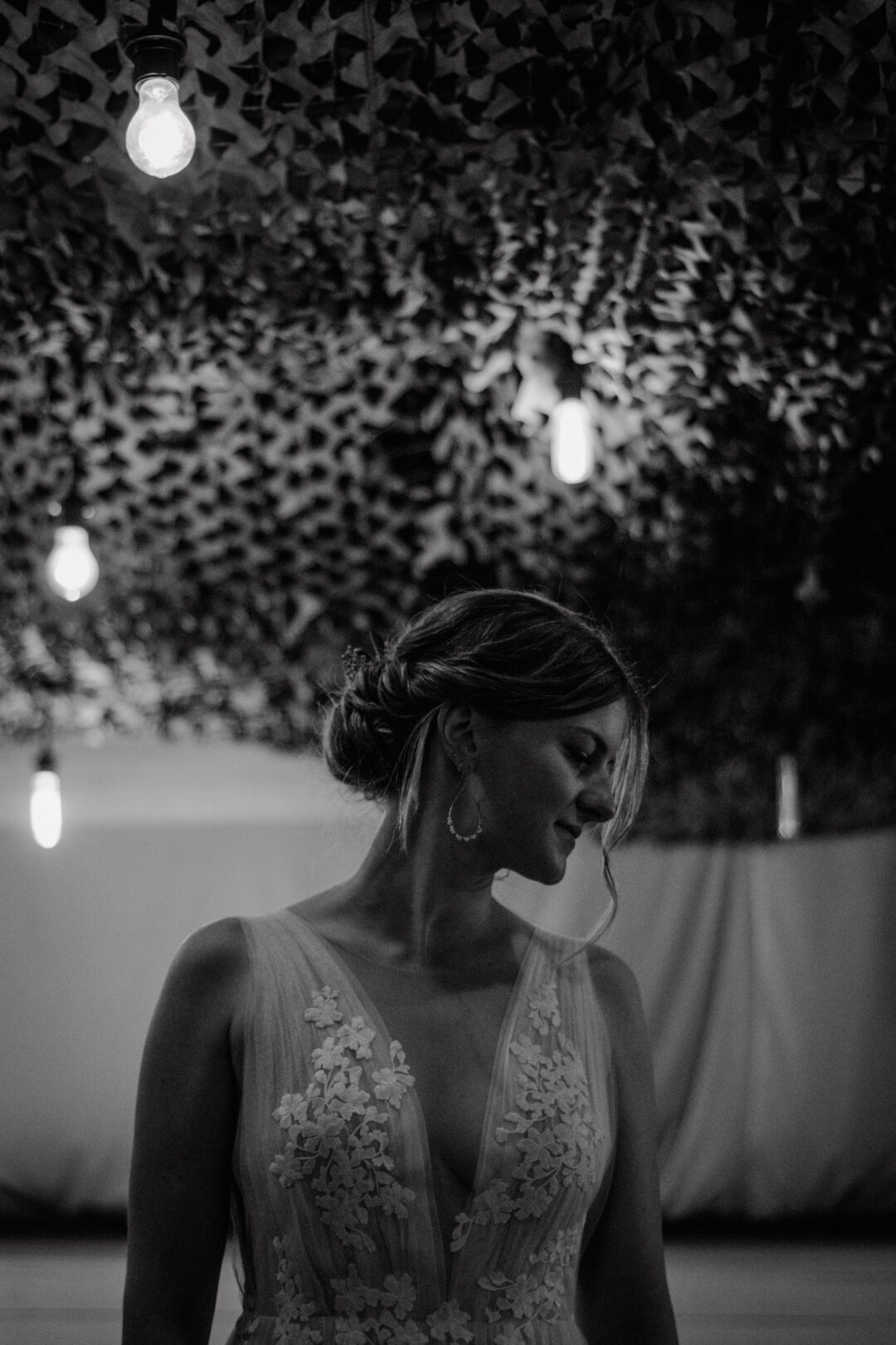 Braut im Halbdunkel unter romantischer Beleuchtung