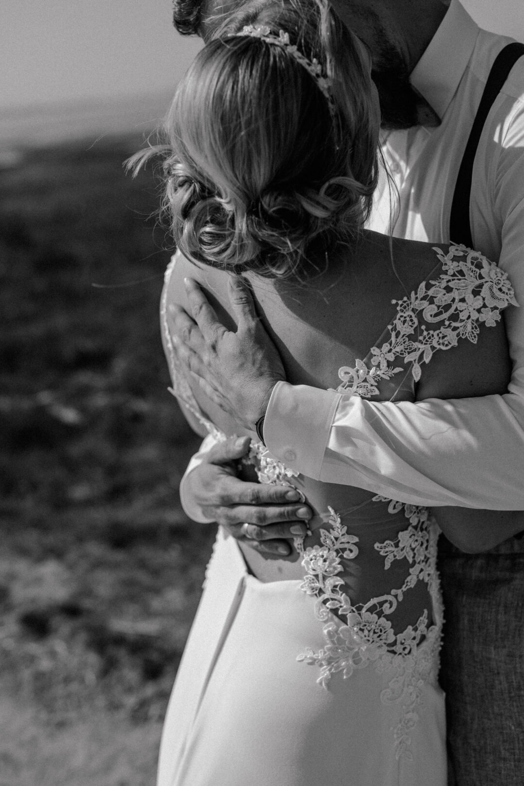 Bräutigam umarmt die Braut von hinten