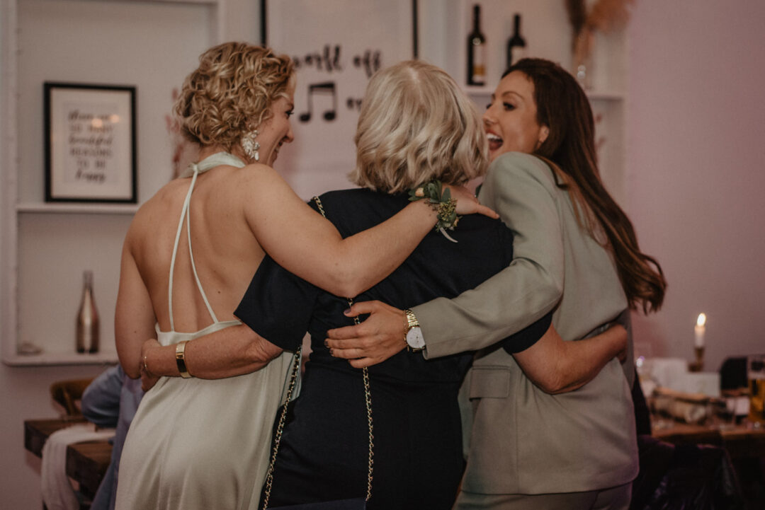 Hochzeitsgäste umarmen sich herzlich bei der Feier