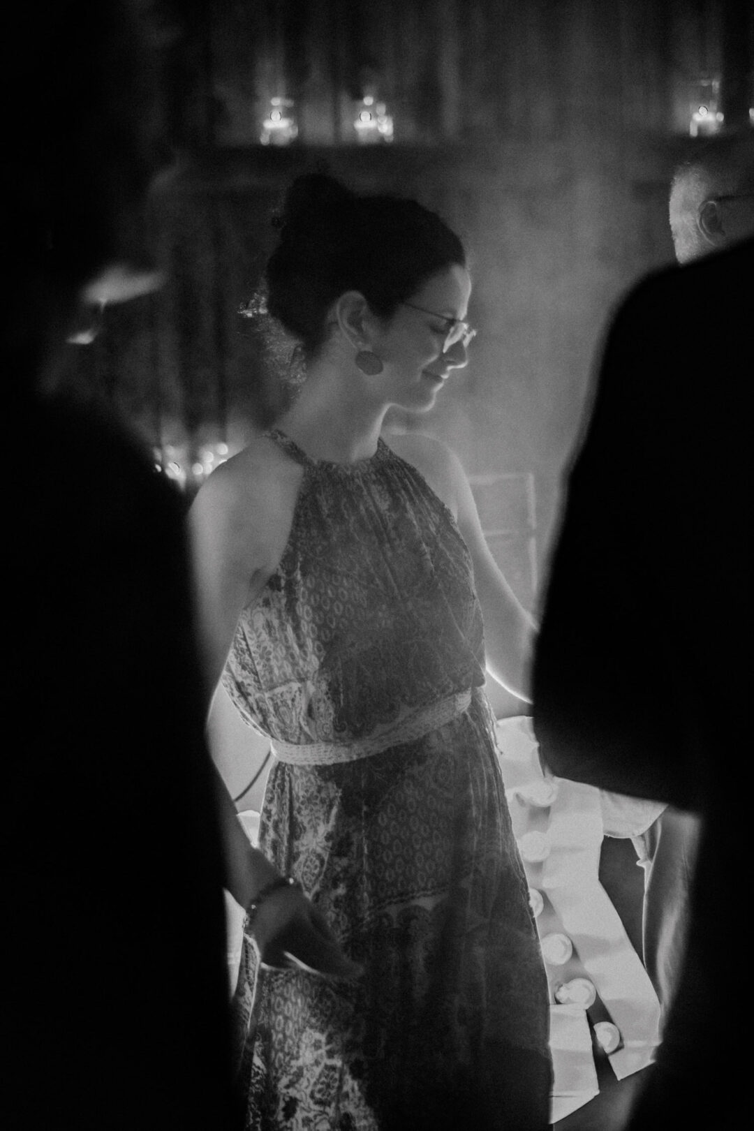 Frau im Boho-Kleid tanzt bei Kerzenschein auf Hochzeit