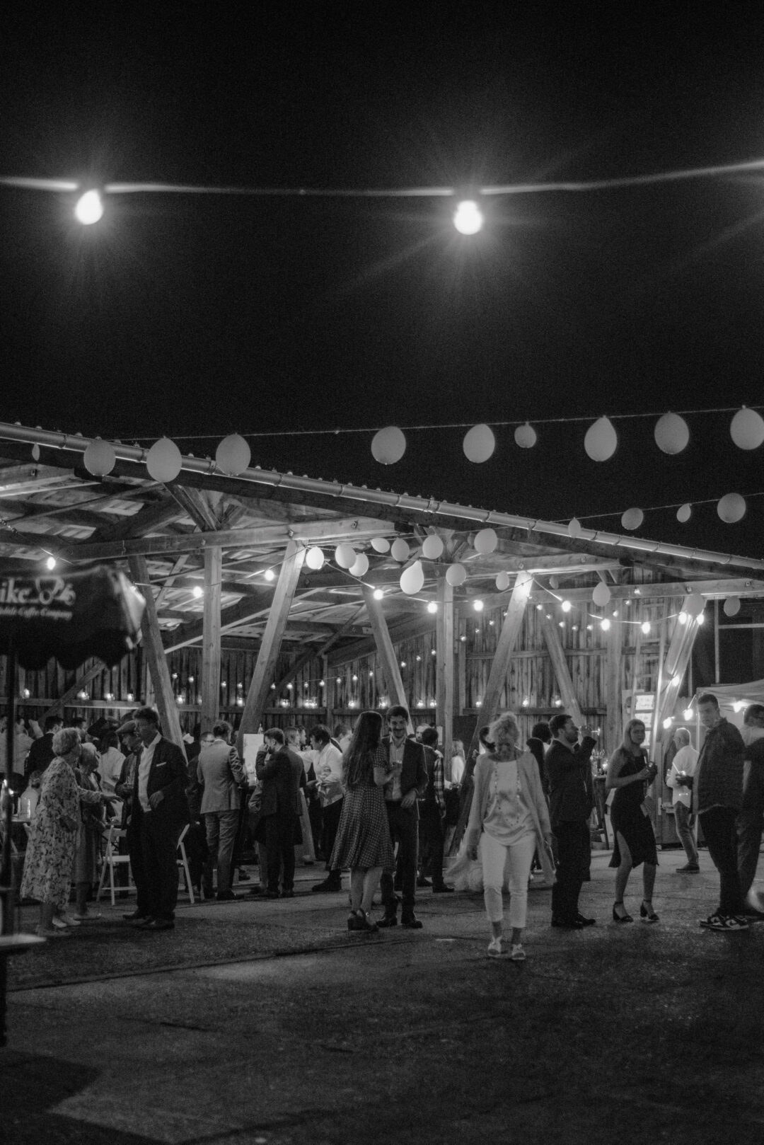 Nachtaufnahme der Hochzeitsgesellschaft unter Lichterketten