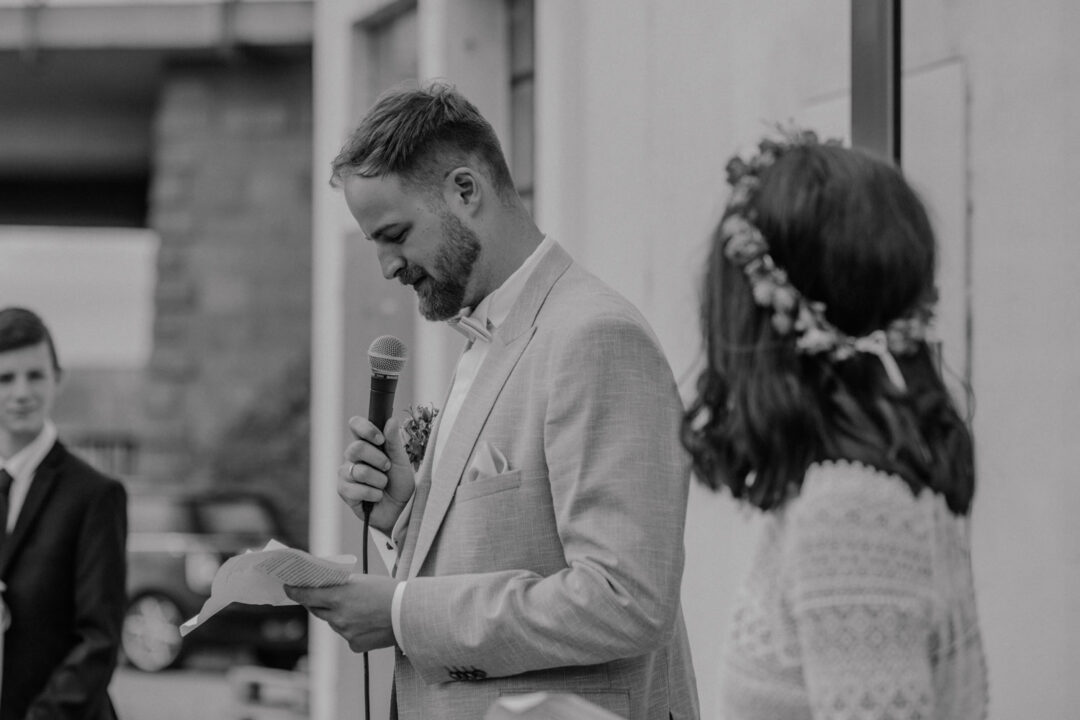 Bräutigam hält Rede mit Mikrofon