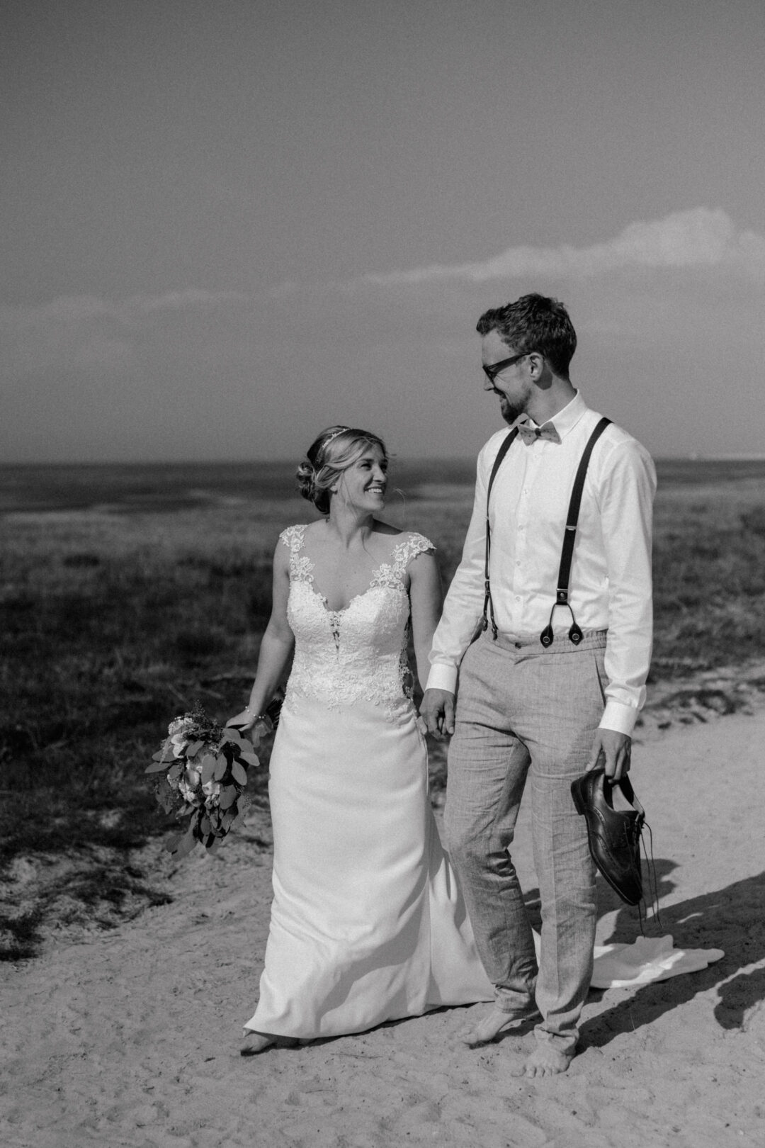 Brautpaar spaziert gemeinsam durch die Dünen
