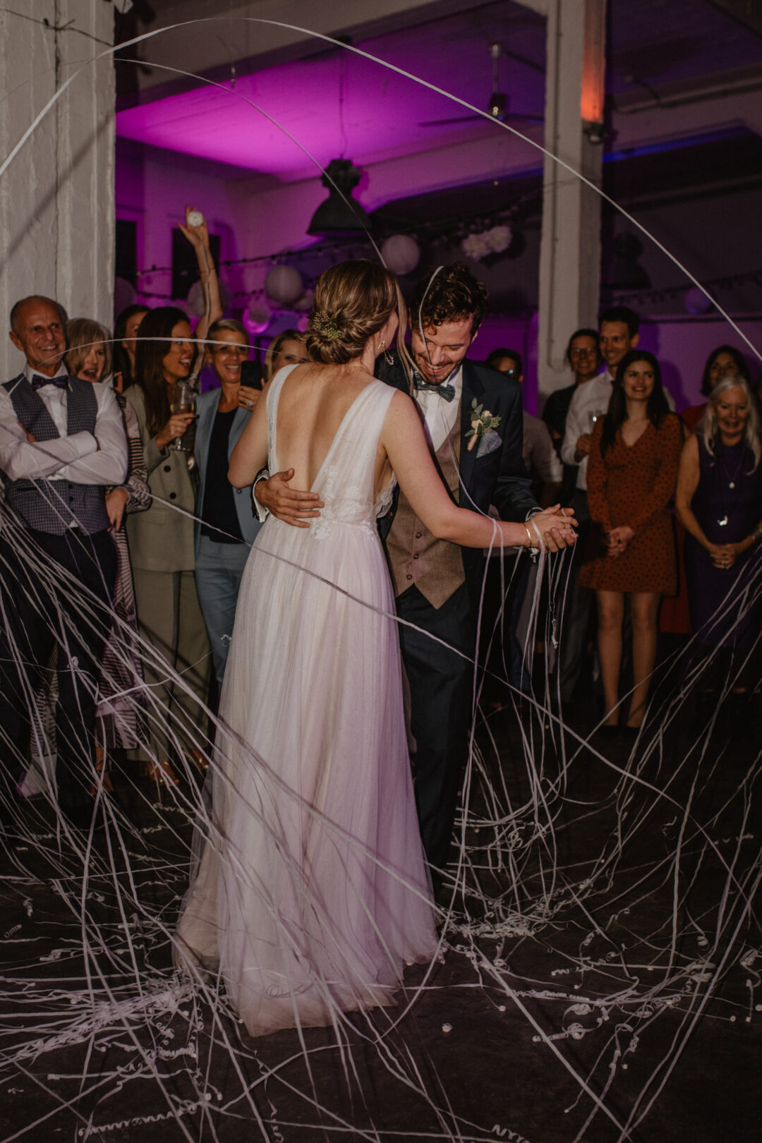 Brautpaar tanzt ausgelassen im Licht der Luftschlangen