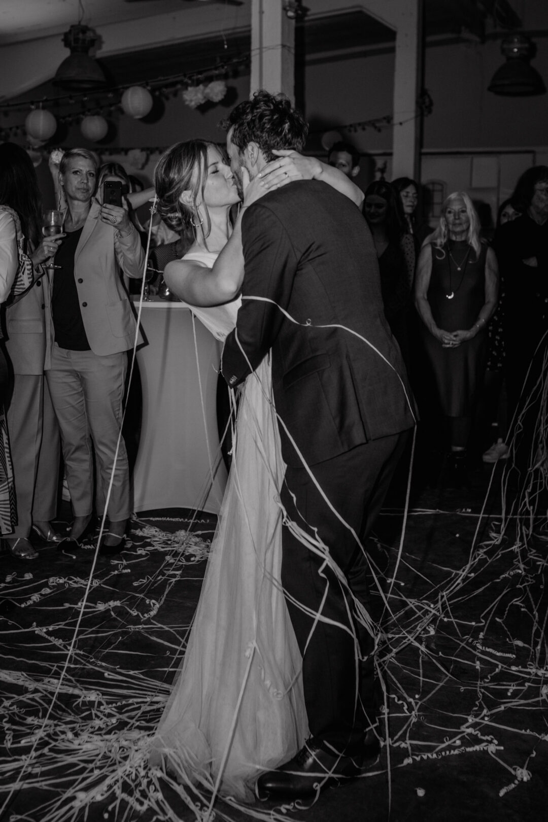 Romantischer Kuss beim Hochzeitstanz in Schwarzweiß