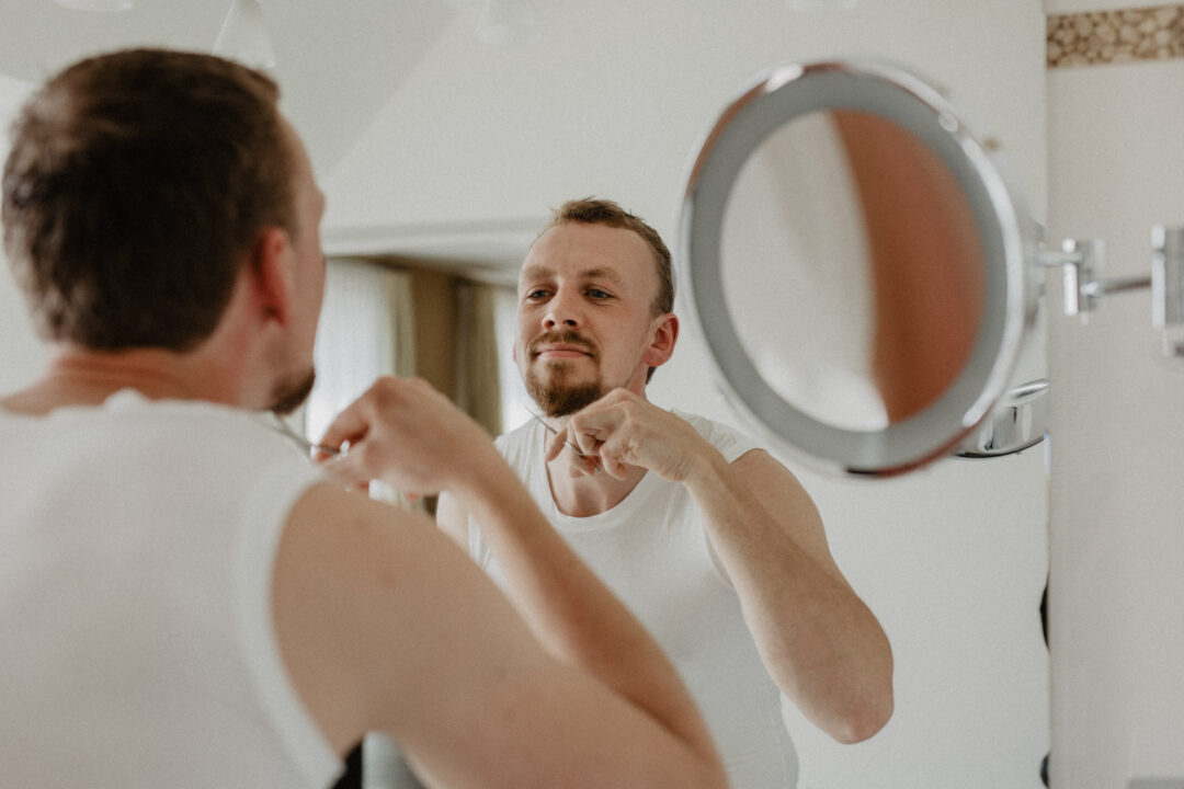 Bräutigam rasiert sich vor Vergrößerungsspiegel