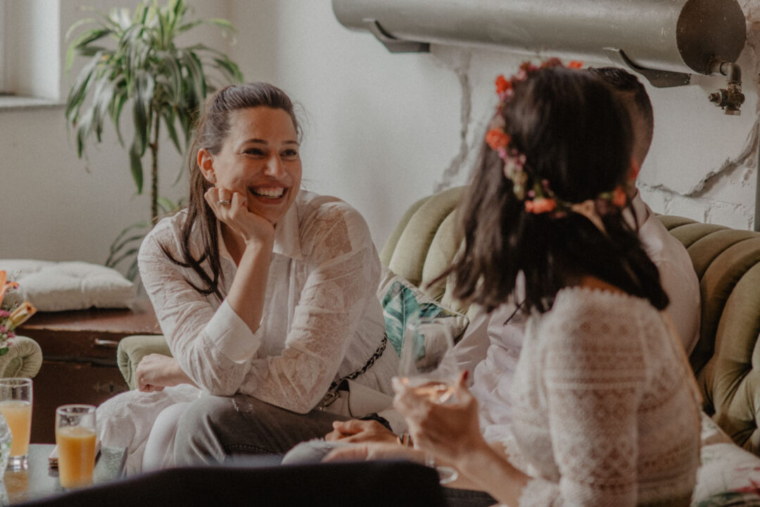 Frau in Weiß lacht in Hochzeitslounge