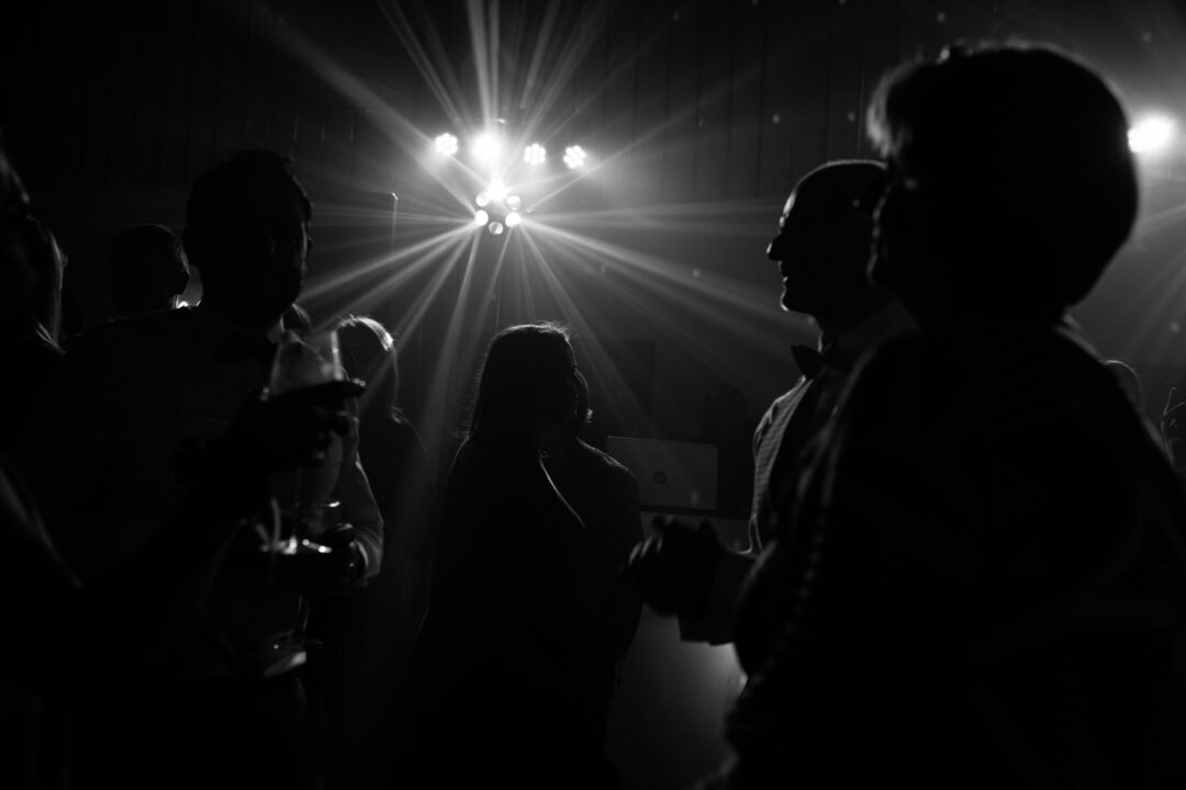 Gäste tanzen wild im Gegenlicht der Hochzeitslocation