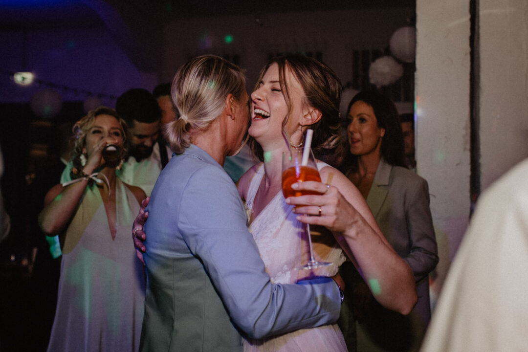 Braut und Freundin umarmen sich auf der Party