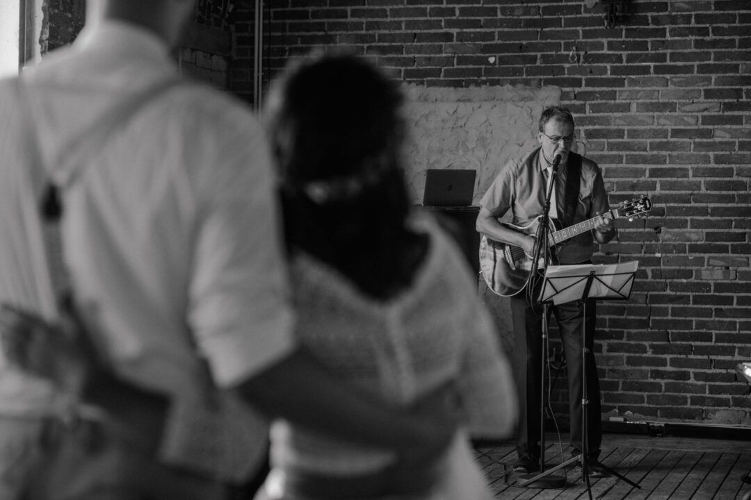 Brautpaar hört Livemusik in Backsteinlocation