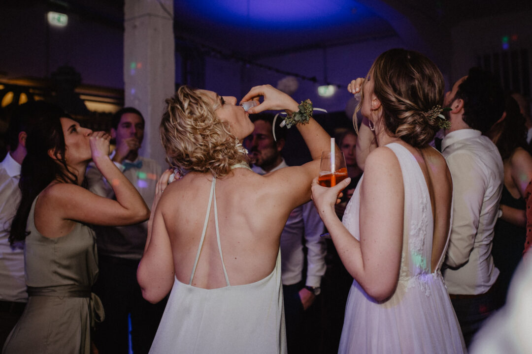 Gäste stoßen mit Cocktails bei der Hochzeitsfeier an