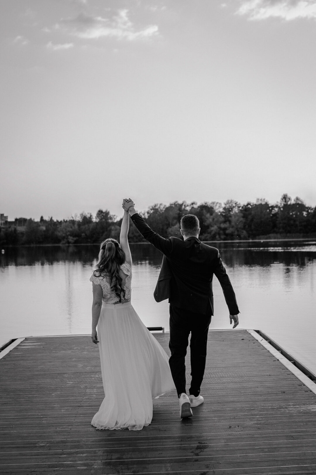 Brautpaar hebt die Hände am See