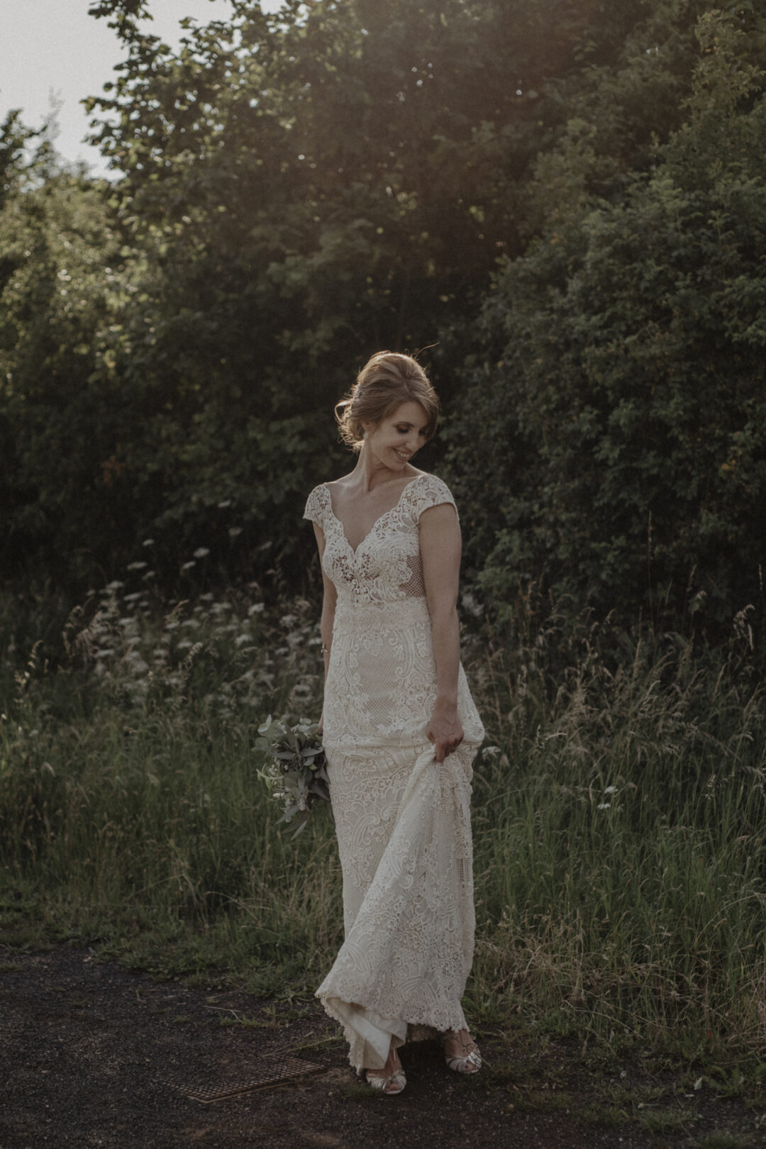 Braut lacht auf der Wiese bei ihrer Hochzeit in Waltrop