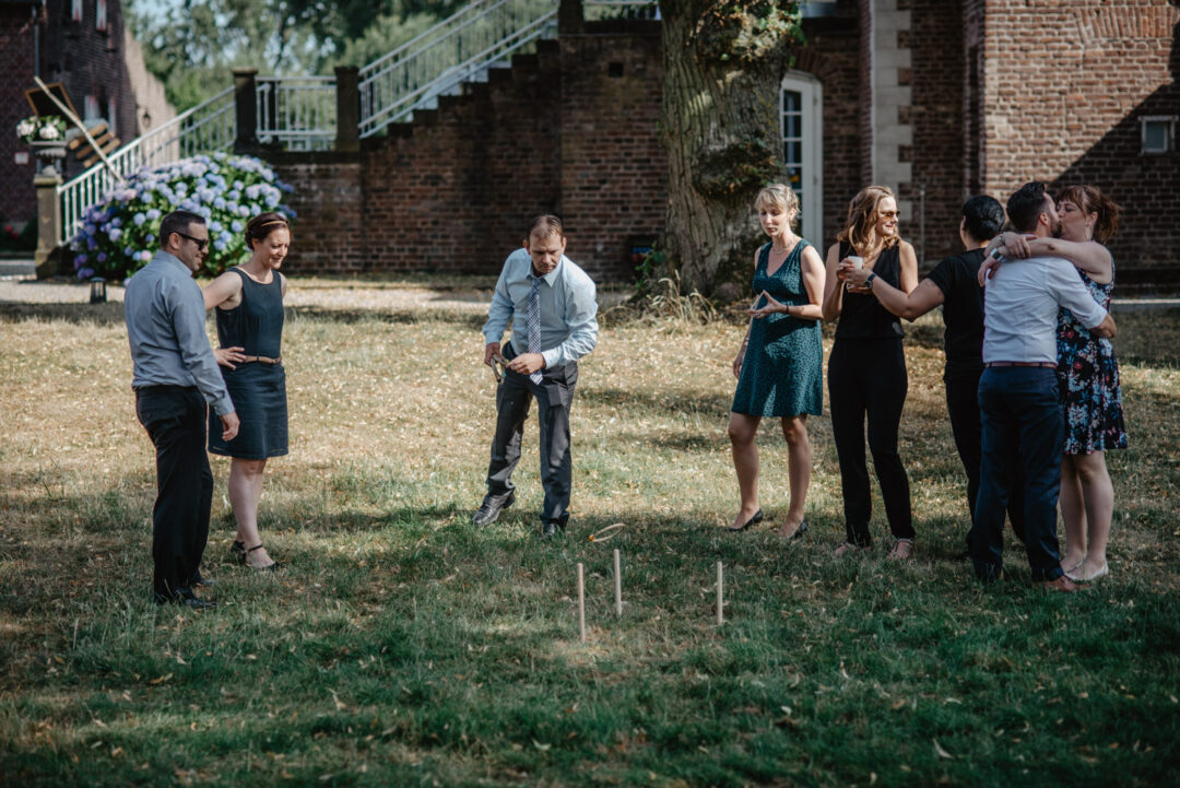 Hochzeitsgäste spielen draußen auf der Wiese
