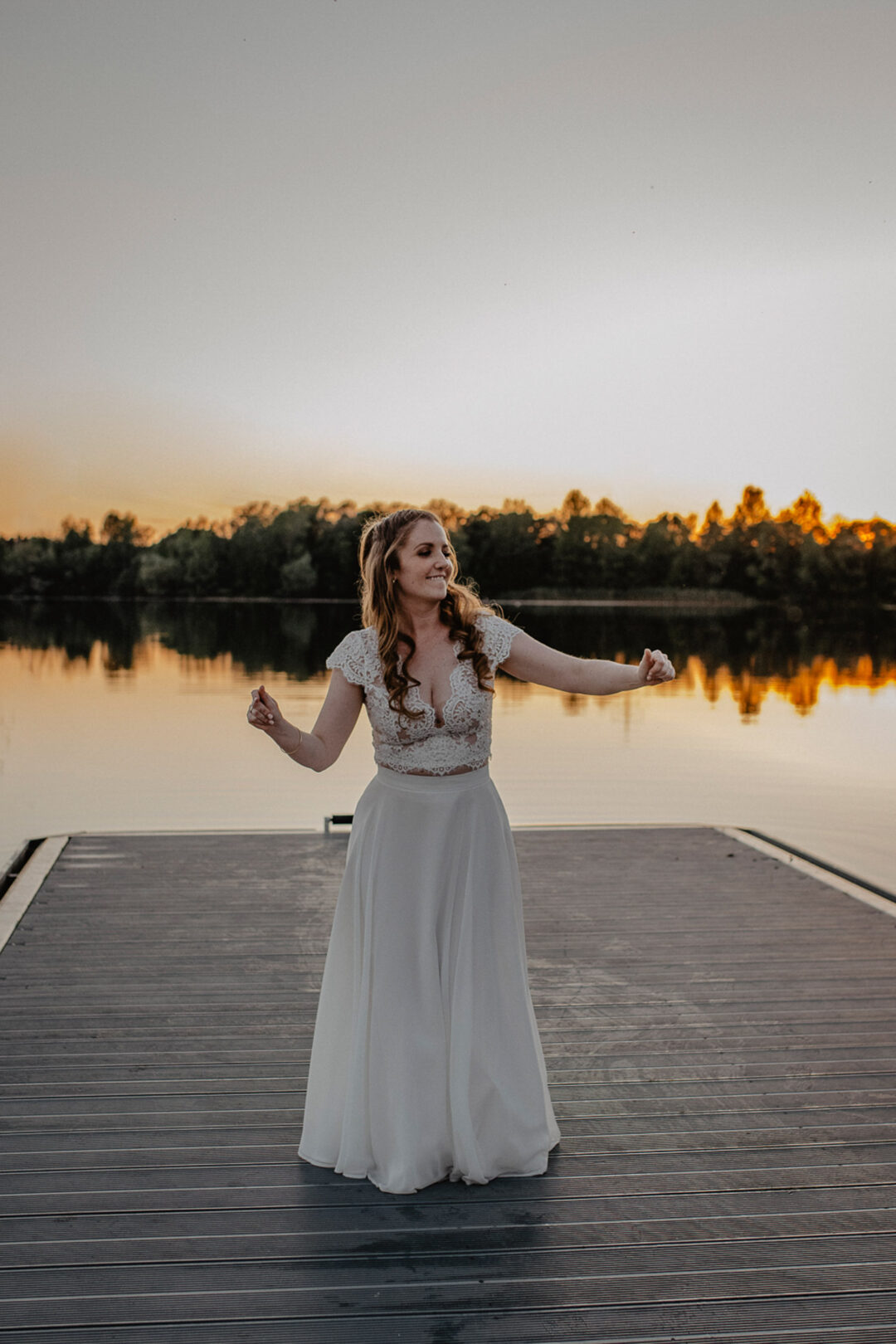 Braut tanzt ausgelassen auf dem Steg