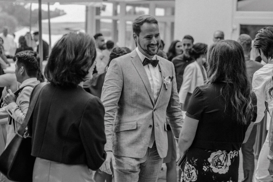 Bräutigam spricht mit Gästen beim Empfang nach der Trauung