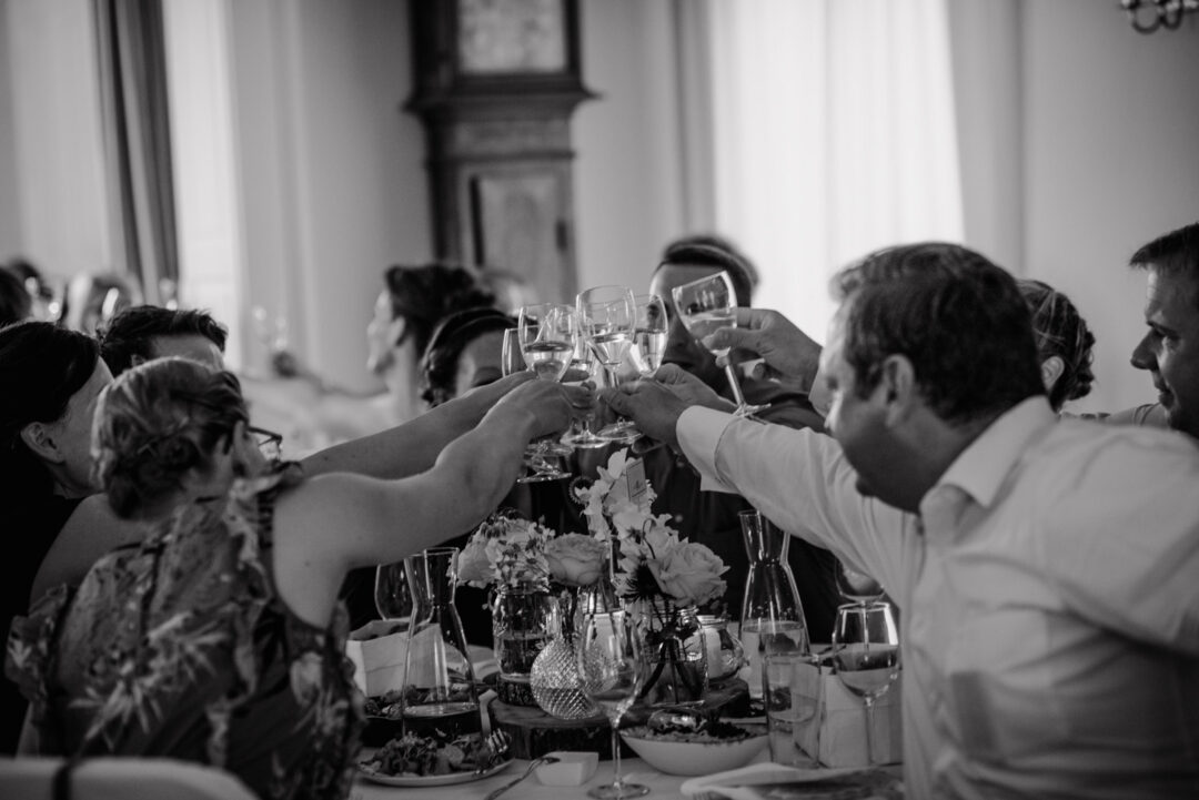 Gäste stoßen mit Sektgläsern bei der Feier an