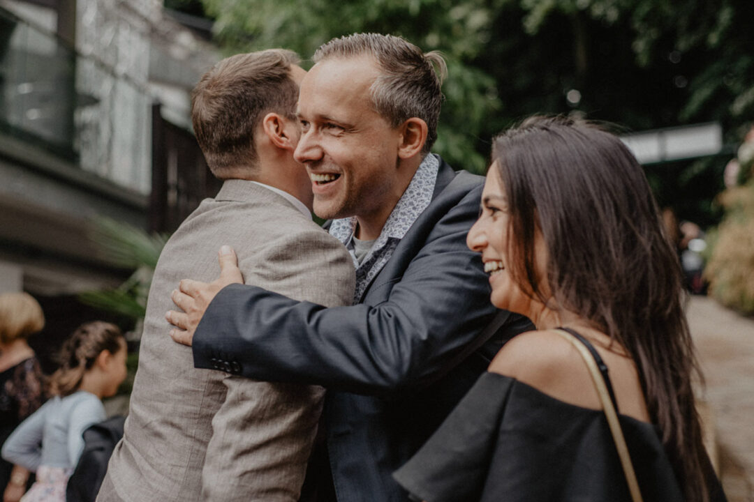 Gäste umarmen den Bräutigam zur Gratulation im Seepavillon