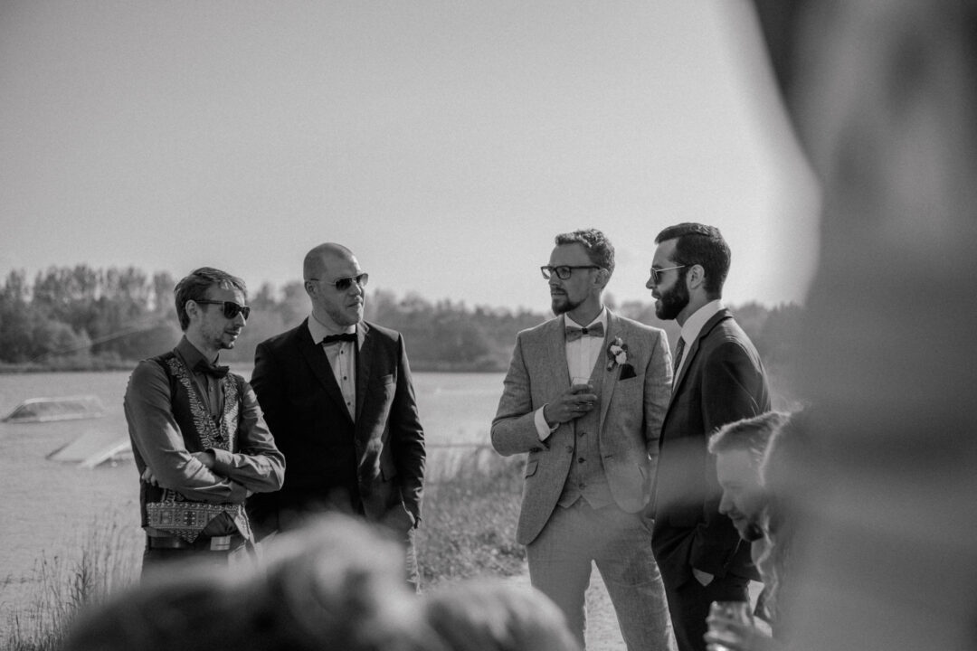 Bräutigam unterhält sich mit Freunden im Außenbereich