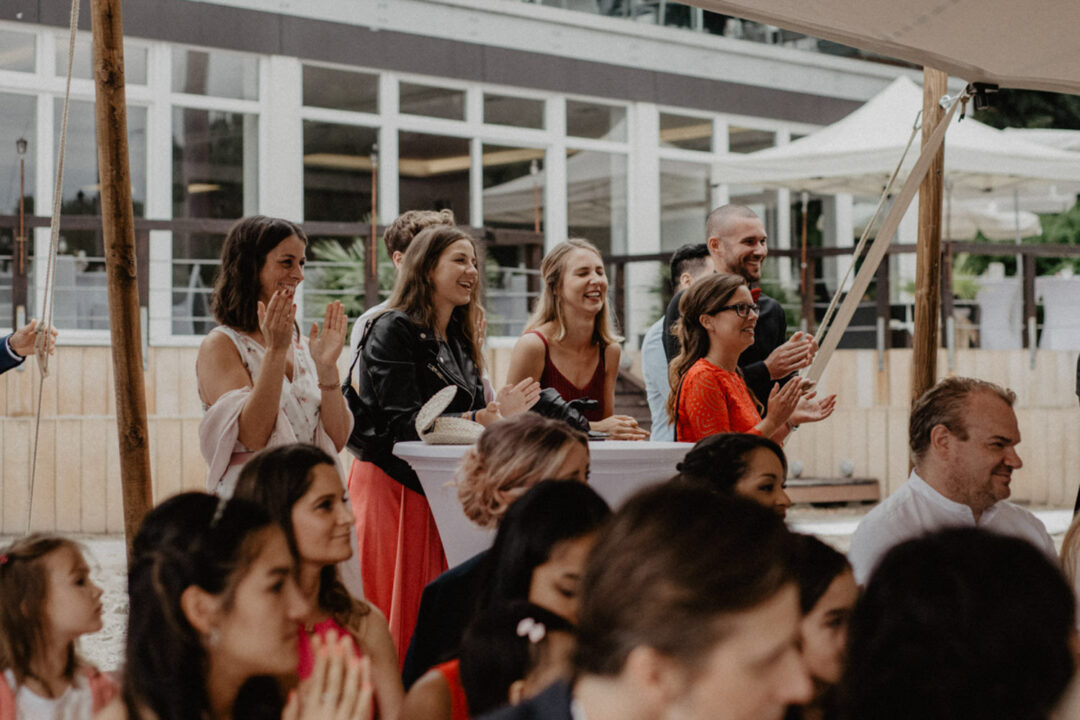 Gäste applaudieren fröhlich während der Trauung am Seepavillon