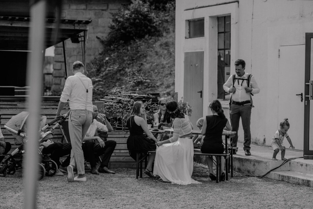 Gäste sitzen im Innenhof bei der Hochzeit