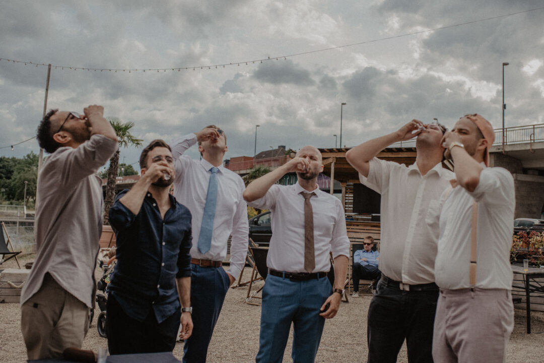 Männergruppe trinkt gemeinsam auf Hochzeit