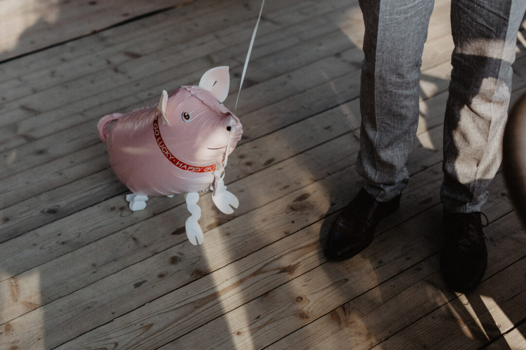 Kind zieht Spielzeug-Glücksschwein vor der Location