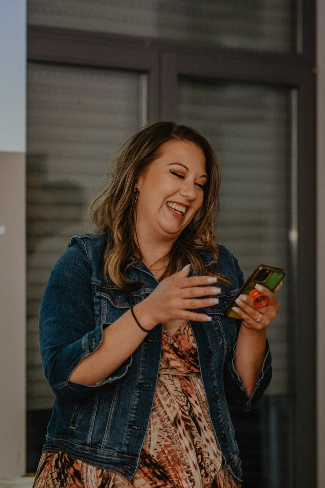 Freundin lacht mit dem Handy in der Hand