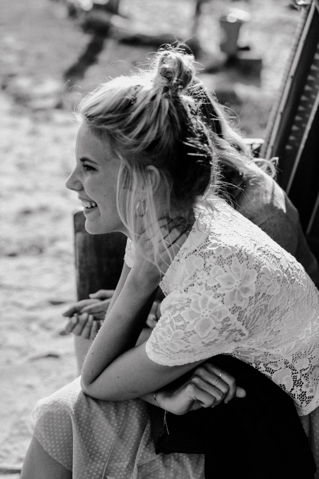 Gast sitzt lachend auf der Terrasse der Location