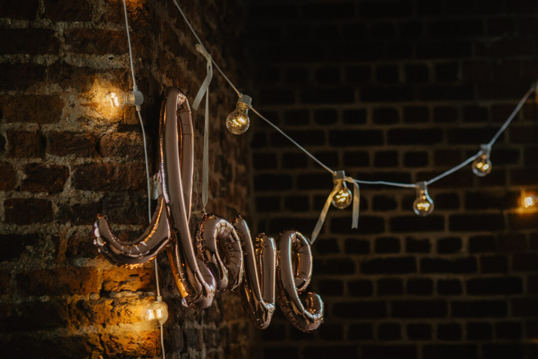 Love-Ballon an Backsteinwand mit Lichterkette