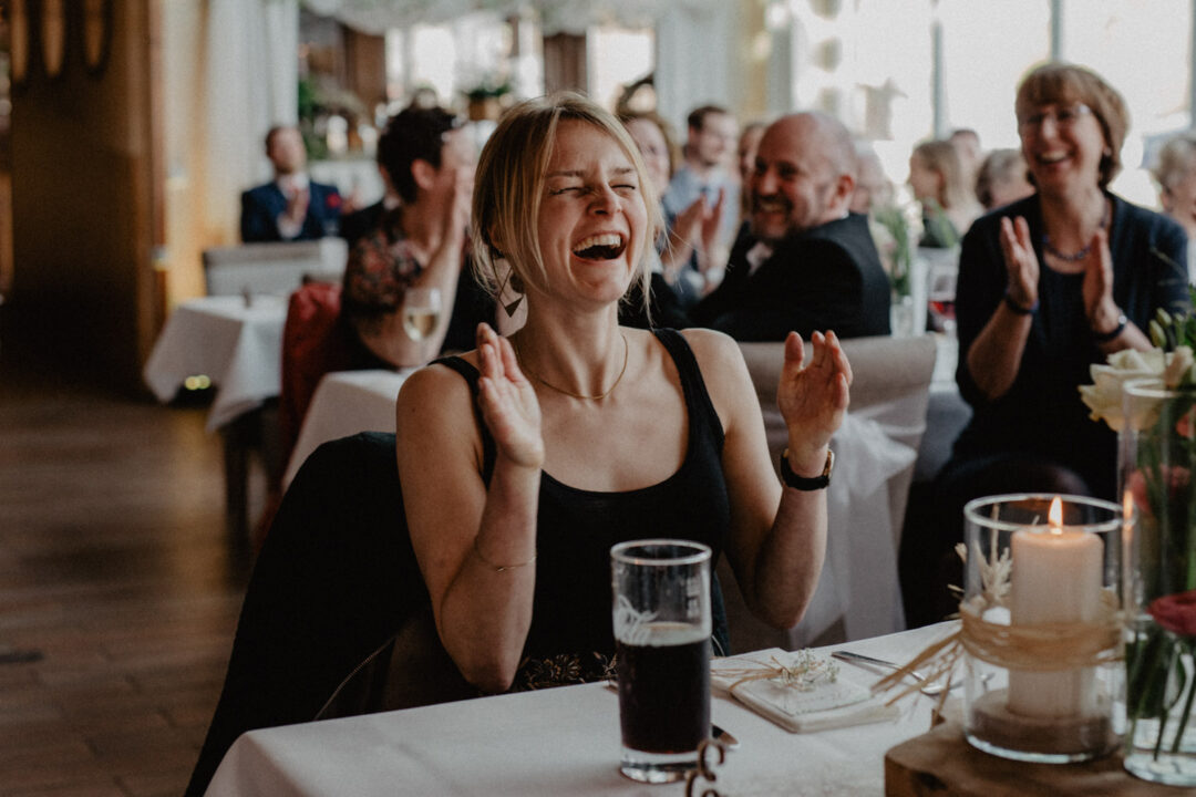 Gästin applaudiert und lacht bei der Hochzeit
