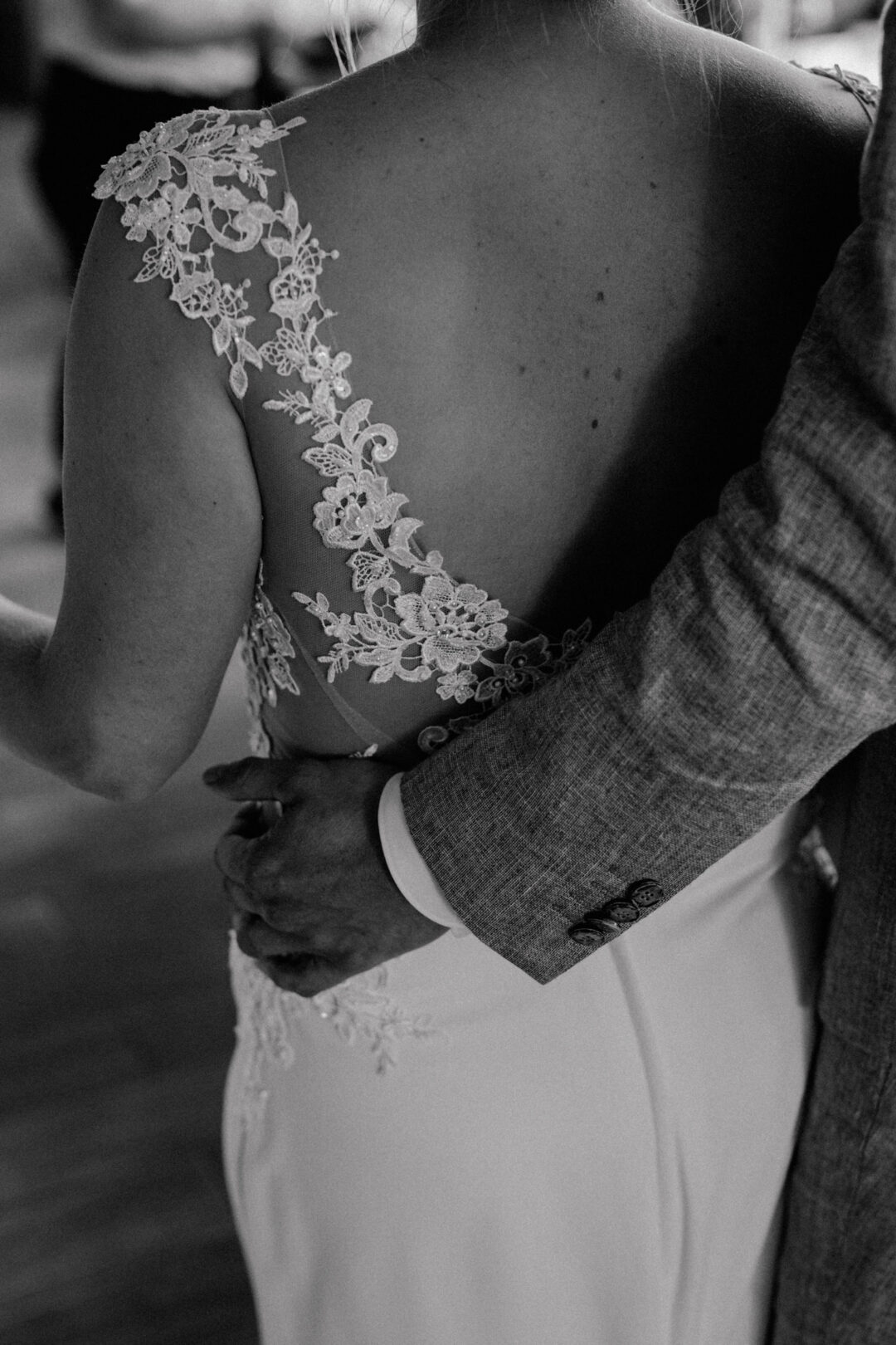 Detailaufnahme der Umarmung von Braut und Bräutigam