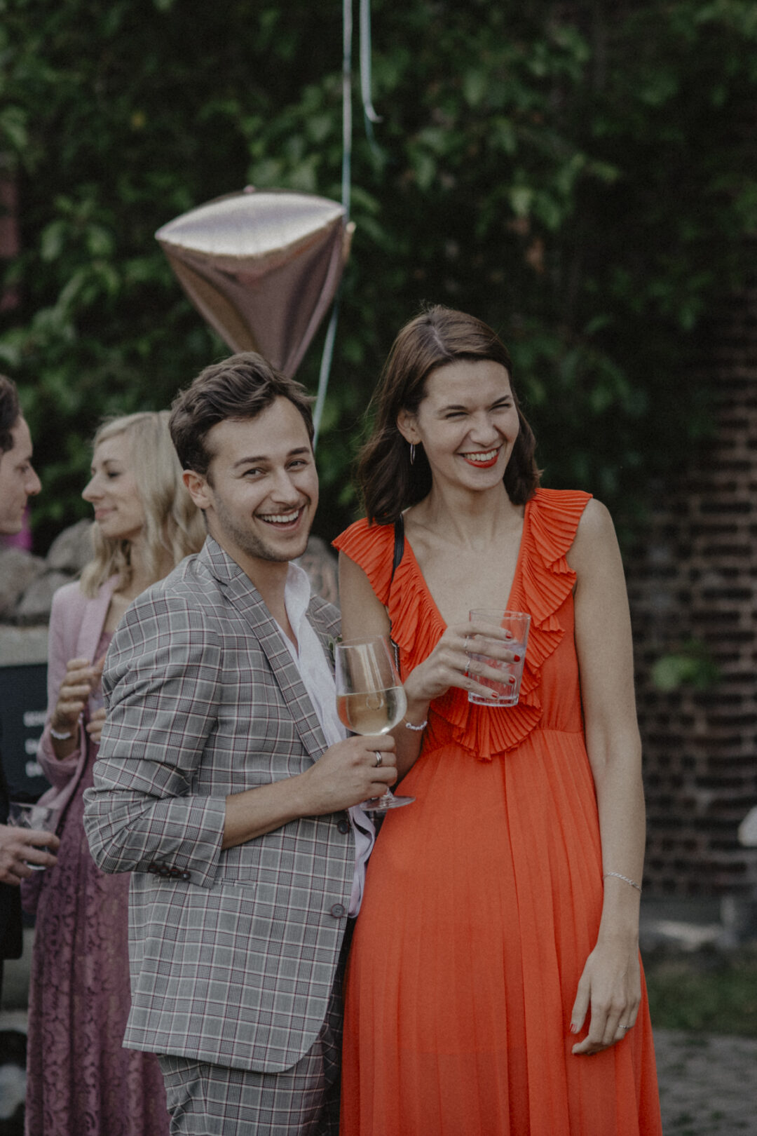 Fröhliche Hochzeitsgäste lachen beim Sektempfang