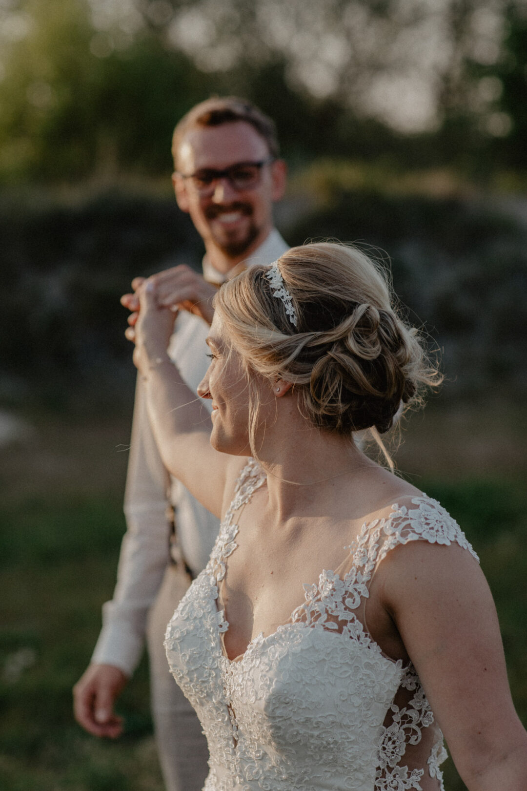 Brautpaar spaziert lachend durch das Abendlicht