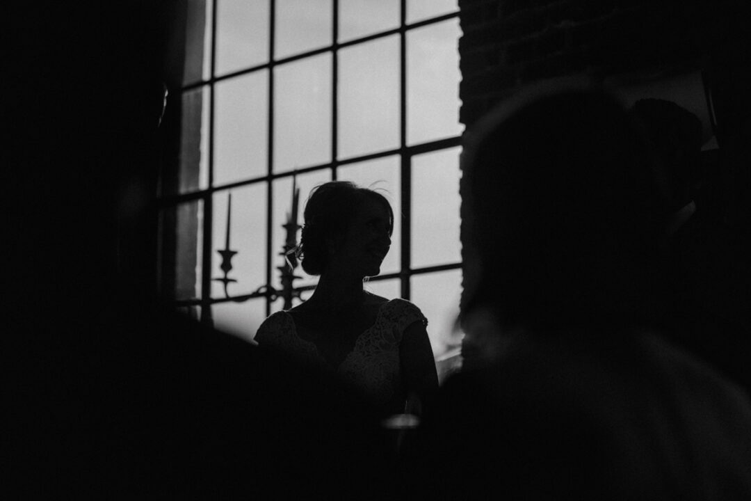 Silhouette der Braut vor Fenster im Industrieambiente