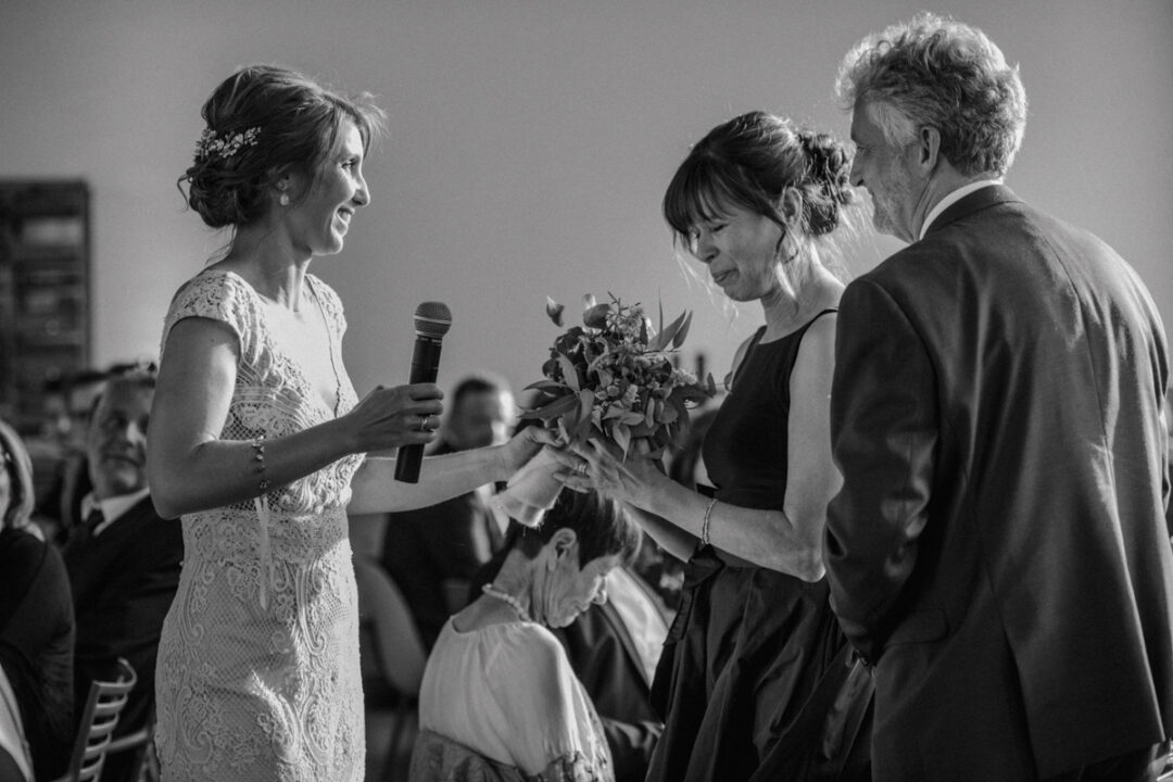 Braut hält Hochzeitsrede und überreicht Blumenstrauß